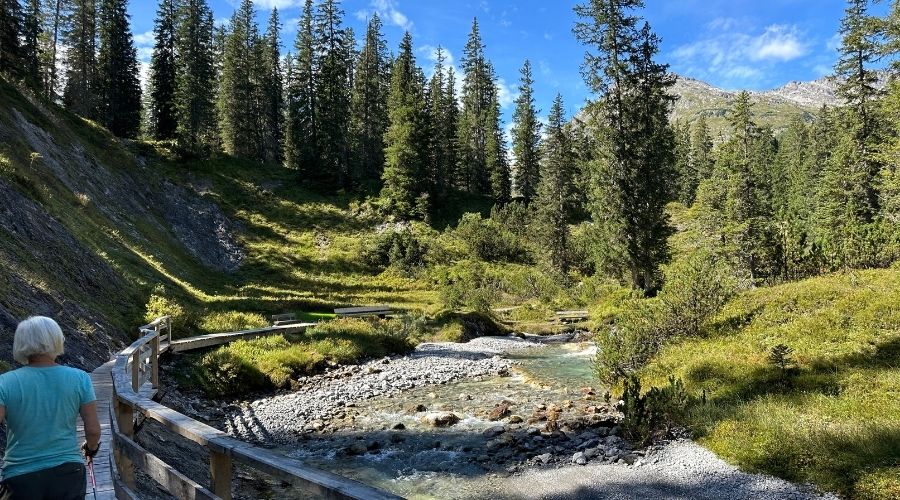 wanderweg, brücke am Bachentlang Gebirgsfluss Wandernde Frau